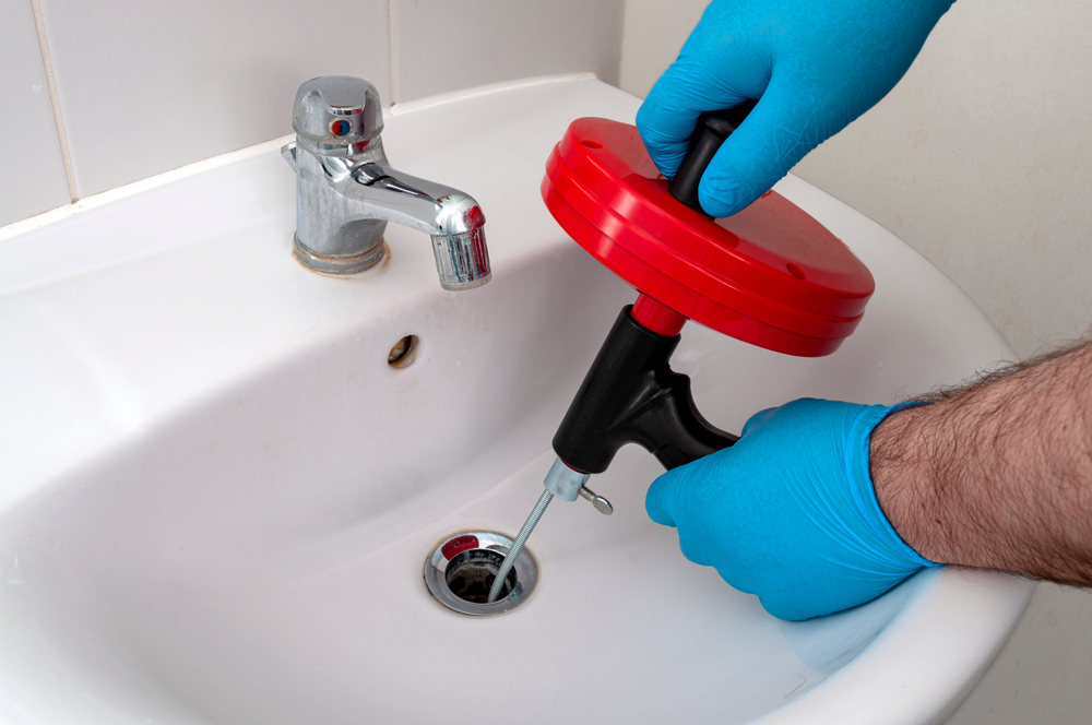 A plumber fixing a clogged drain.